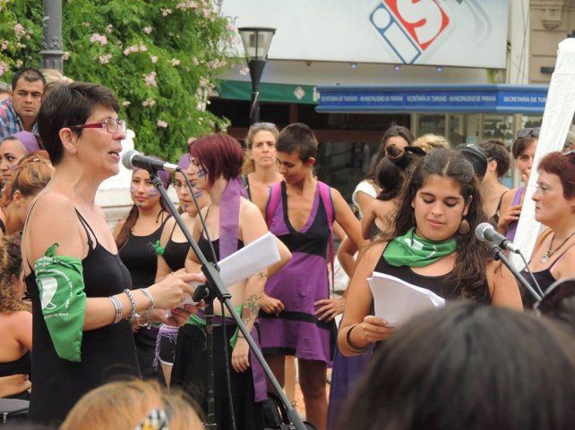 Jorgelina leyendo frente al micrófono en la plaza 1° de Mayo.